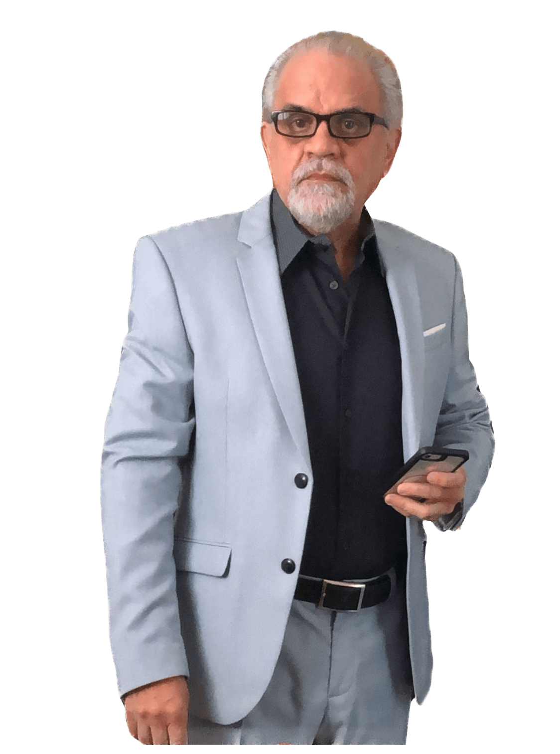Hombre mayor con traje gris claro, gafas y barba canosa sosteniendo un teléfono móvil.